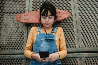 girl-with-smartphone-and-skateboard-lying-on-walkw-2022-03-04-05-49-25-utc