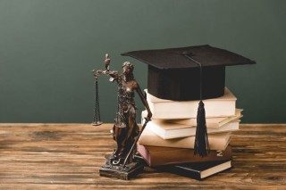 themis-statuette-books-and-academic-cap-on-wooden-2023-11-27-04-45-25-utc